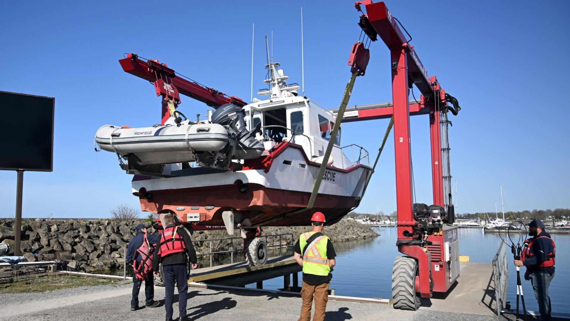 As members of Port Colborne Marine Auxiliary Rescue Unit watch a city of Port Colborne Sugarloaf Marina employee use a travel lift to launch the unit’s main rescue boat.